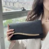 Μαύρη clutch τσάντα με κυματιστό χρυσαφί μεταλλικό κούμπωμα