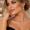 Γυναίκα που φορά ασημί σετ κοσμημάτων με κολιέ, βραχιόλι και κρεμαστά σκουλαρίκια
